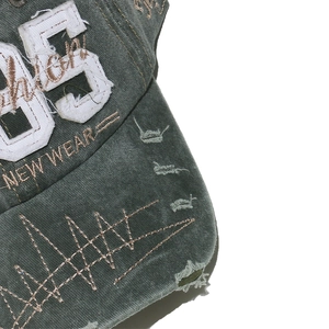 Detailed embroidery on vintage baseball cap with 85 patch and worn distressed texture