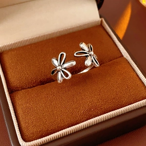 Macro shot of silver hollow flower open ring detail on a brown velvet jewelry box