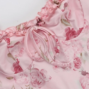 Detalle de vestido floral rosa con escote de volantes y tirantes finos para anudar