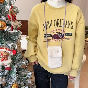 Detail of white teddy fleece phone bag with purple rope strap on a yellow sweatshirt