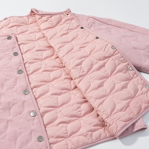 Detail shot of pink quilted jacket featuring petal-shaped stitching and metal snap buttons
