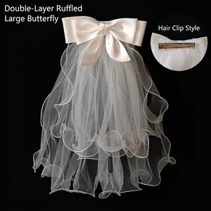Detail of white two-layer rolled edge bridal bow hair clip with satin and tulle mesh