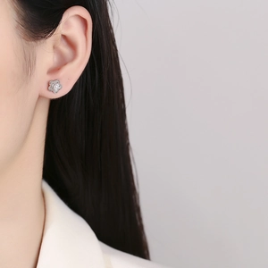 Elegant 925 sterling silver camellia flower earrings with central white pearl on a model