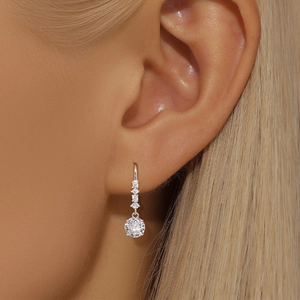 Macro shot of S925 sterling silver drop earring with round sparkling zircon on a model