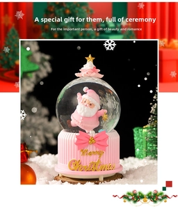 Detailed view of pink Christmas music box with Santa Claus figurine and gold glitter decor