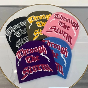 Double-sided jacquard knit beanies with Through The Storm text in multiple colors