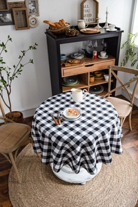 Tovaglia rotonda classica a quadretti neri e bianchi in una accogliente sala da pranzo rustica