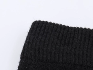Macro view of black knit fabric texture showing high-quality ribbing and soft material