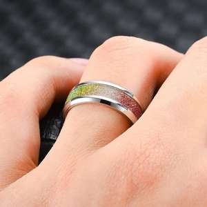 Close-up detail of stainless steel ring with colorful gradient glitter inlay on finger