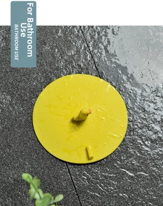Close-up of yellow silicone floor drain cover with cute duck handle on bathroom tiles