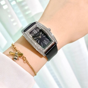 Luxury women's rectangular watch with rhinestones and black leather strap on wrist