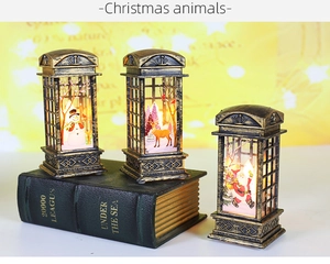 Macro shot of vintage Christmas phone booth lantern with warm LED light and Santa figure