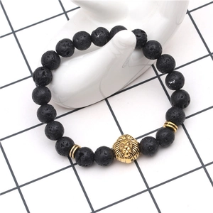 Close-up of black lava stone bead bracelet with golden lion head on hand model