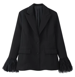 Dettaglio del polsino del blazer nero con finiture in piuma e trama in tessuto opaco