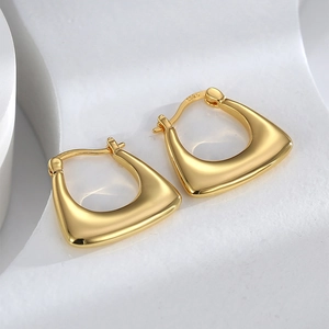Macro shot of gold geometric earrings with S925 hallmark on a minimalist white background