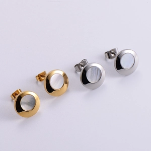 Detail showing elegant gold and silver circular stud earrings with shell inlay