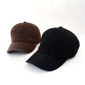 Detailed close-up of distressed vintage baseball caps with ripped holes and worn cotton texture