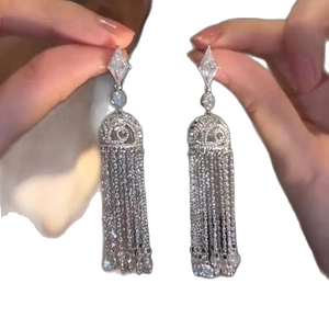 Boucles d'oreilles luxueuses à pompons argentés avec cristaux et chaînes élégantes