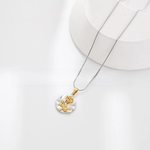 Detailed macro view of a silver necklace featuring a textured pendant with a gold rose