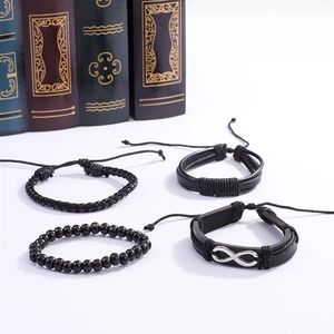 Détail de bracelets en cuir noir tressé et perles sur des livres vintage