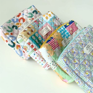 Quilted floral cotton cosmetic bags in four colorful patterns on white background