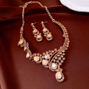 French vintage gold jewelry set with champagne crystals on dark brown silk background