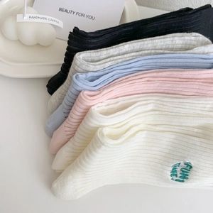 Close-up of colorful ribbed knit socks with FUN TIME embroidery and textured patterns