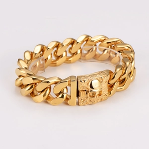 Detailed view of gold Cuban link bracelet with skull clasp on white background
