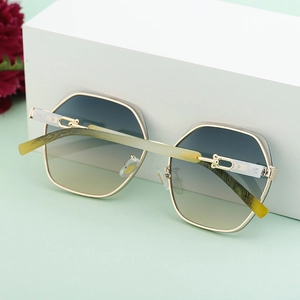 Detailed shot of polygon gold metal frame sunglasses with blue-yellow gradient lenses