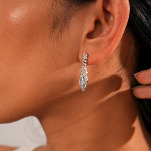 Close-up of elegant silver water-drop earrings with sparkling crystals on a model