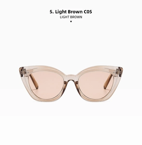 Detail view of light brown cat-eye sunglasses with metal rivets and transparent frames