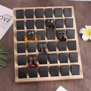 Bamboo 36-slot earring display tray with black cards on a wooden tabletop