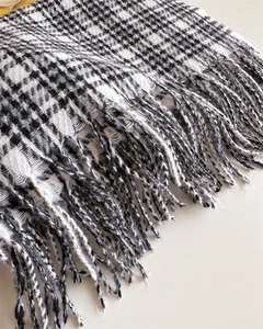 Macro detail of houndstooth weave fabric and fringe tassels on winter cashmere-like shawl