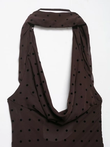 Detail of sheer brown polka dot mesh fabric featuring a halter neck and draped collar