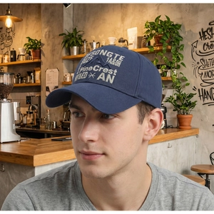 Detailed view of white embroidery on a navy vintage baseball cap worn in a cafe