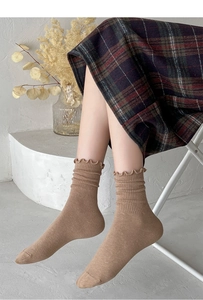 Detailed view of camel mid-calf socks featuring ruffle cuffs and vertical ribbed texture