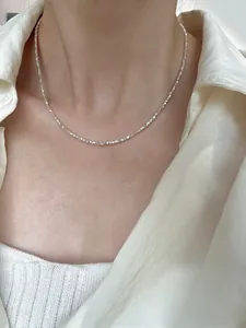 Close-up of S925 sterling silver clavicle chain with shimmering metallic texture on model