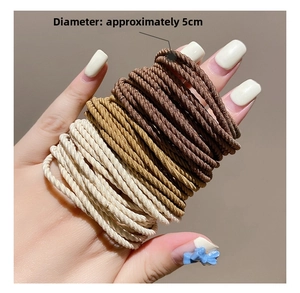 Detail showing elastic hair ties in neutral tones being stretched to show high elasticity