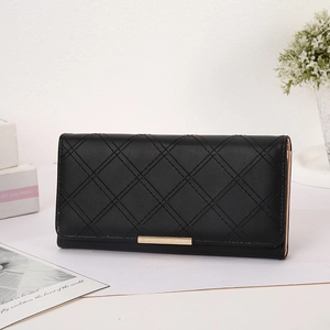 Detailed macro view of black quilted faux leather long wallet with gold metal buckle