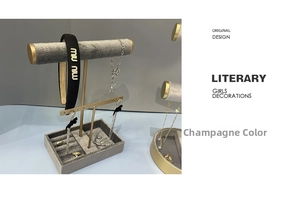 Close-up of champagne velvet jewelry display stand with golden metal T-bar rack