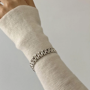 Vintage silver chain bracelet with white crystal rhinestones on a beige knit sleeve