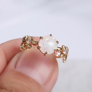 Dettaglio di un anello a foglia con opale sintetico e cristalli rosa su fascia oro