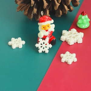 Macro detail of Santa Claus pendant and white glitter snowflakes on festive background