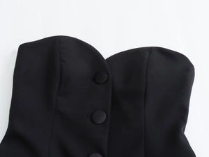 Dettaglio del top a fascia nero con bottoni rivestiti e scollatura a cuore chic