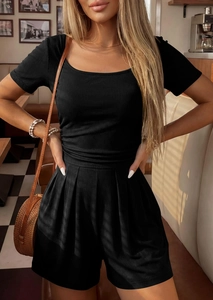 Detail of square neck black ribbed knit romper featuring pleated hem and side texture