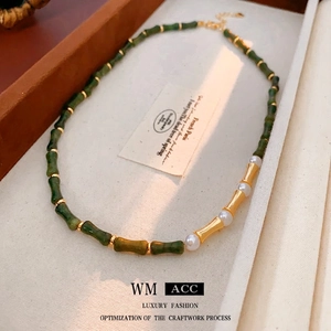 Elegante collana stile bambù con perline di resina verde e perle in finitura dorata