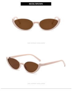 Detail view of beige cat-eye sunglasses with brown lenses and golden metal hinge