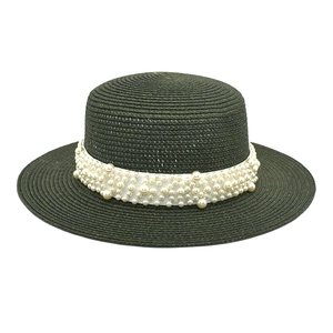 Vue détaillée d'un chapeau de paille sombre avec d'élégantes décorations en perles blanches