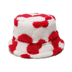 Detail of red and white cow print plush bucket hat with thick faux shearling texture