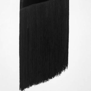 Robe noire minimaliste à franges avec ourlet asymétrique et longs glands sur fond blanc